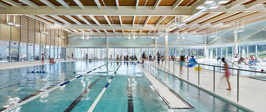 A view of the LCLC pool shows multiple lanes and people walking along the side.